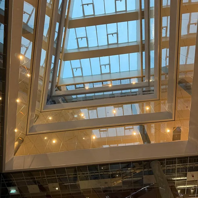 Glassatrium med åpent tak og flere nivåer.