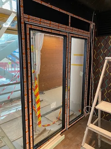 Montering av glassdører i næringsbygg.