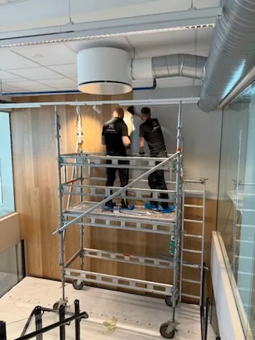 Installasjon av veggpanel i næringsbygg.
